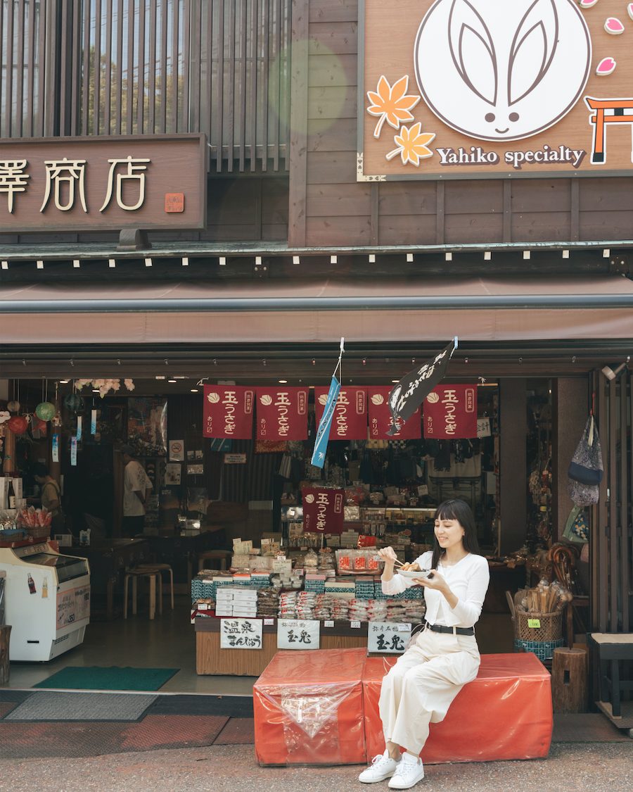 弥彦の門前通りで名物を味わう女性旅行者